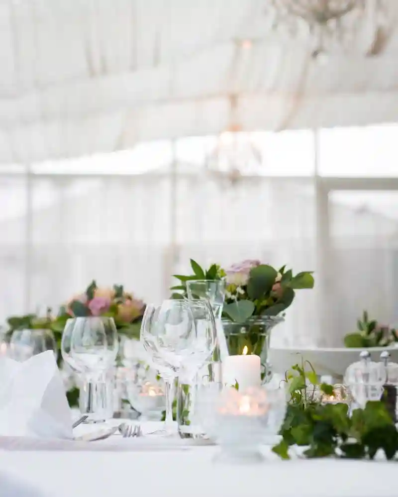 Svatební stůl se zapálenými svíčkami vše v bílé barvě 