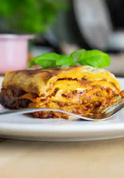 Boloňské lasagne s hovězím masem a sýrem pecorino naservírované na talíři.