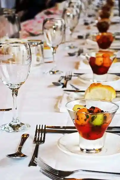 Svatební stůl s připravenými skleničkami na víno a naservírovaný dezert